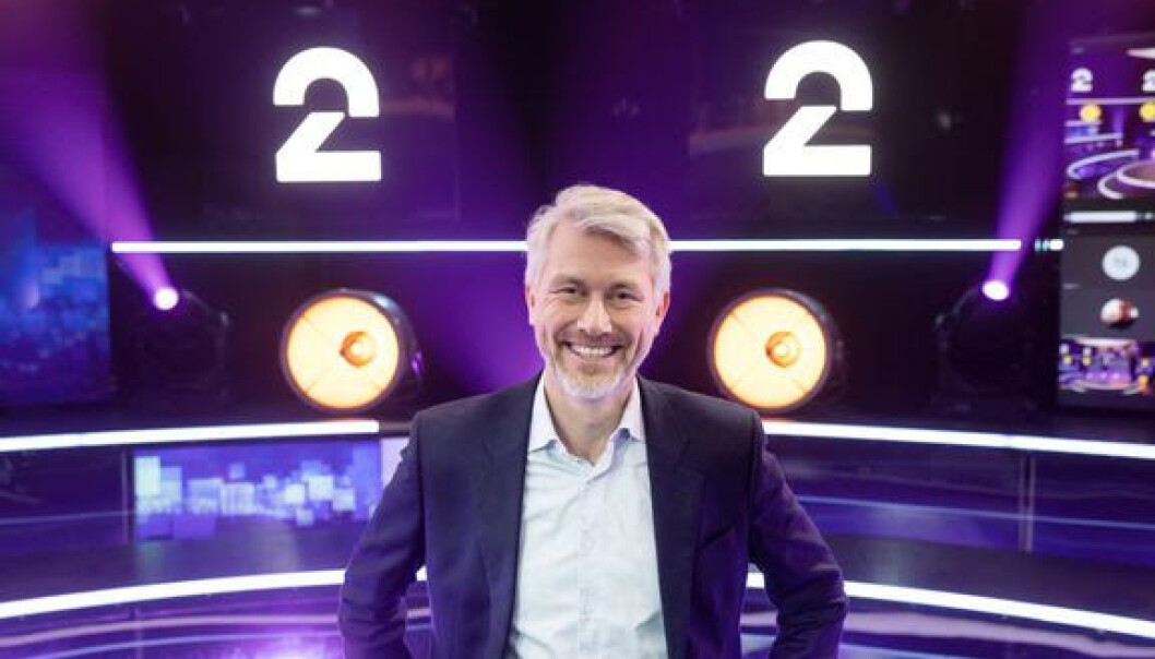 TV 2-sjef Olav T. Sandnes med TV 2 sin nye logo bak TV 2-sjef Olav T. Sandnes med TV 2 sin nye logo bak