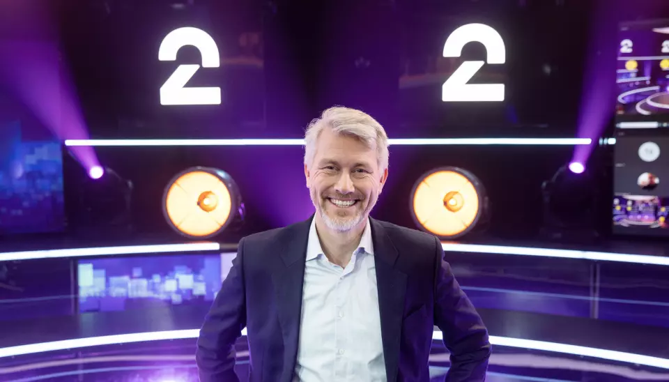 TV 2-sjef Olav T. Sandnes foran den nye logoen til TV2. Nå er TV 2s rebranding nominert til europeisk prestisjepris.
