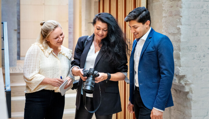 NTB søker produktspesialist (Customer success manager) til vikariat i NTB mediebank tre personer i jobbsammenheng, en person viser de andre noe på kameraet