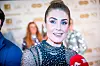 Tone Damli Aaberge smiler foran en sponsorvegg, iført en glitrende svart topp.