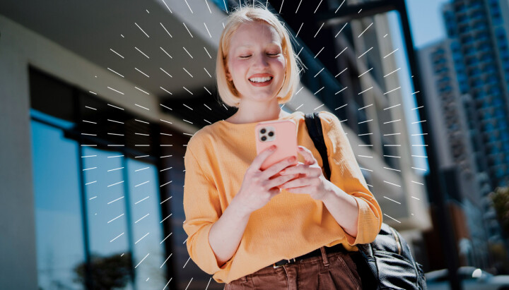 Carat – pioneren innen media Dame som smiler til mobilen sin.