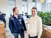 Lasse Torstenson og Tord Sollie smiler i et lyst, åpent kontorlandskap