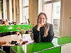 Kristina Skogen lent mot en grønn kontorpult i et lyst fellesområde