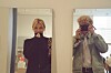 To personer tar speilselfier i et lyst rom.