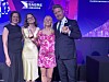 Tre personer står på en prisutdeling og holder glasspriser foran en Sabre Awards-bakgrunn.