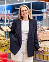 Stine Sjølie står i en Coop Obs-butikk ved hyller og handlevogner.
