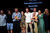 En gruppe personer står på scenen og feirer en pris under en visning i Cannes.