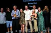 En gruppe mennesker står på en scene i Cannes med en gullpris i hånden.