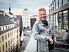 Hogne Malum Gjersvik på en terrasse med bylandskap i bakgrunnen.