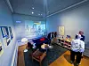 Bureau-stand på Tigerbrøl med videoprojeksjon, sittegruppe, utstillingshyller og en besøkende.