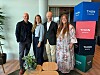 Fem personer står i en hotellobby ved stablede Thon Hotels-logoer.