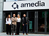 Fire personer foran inngangen til Amedia-kontoret.
